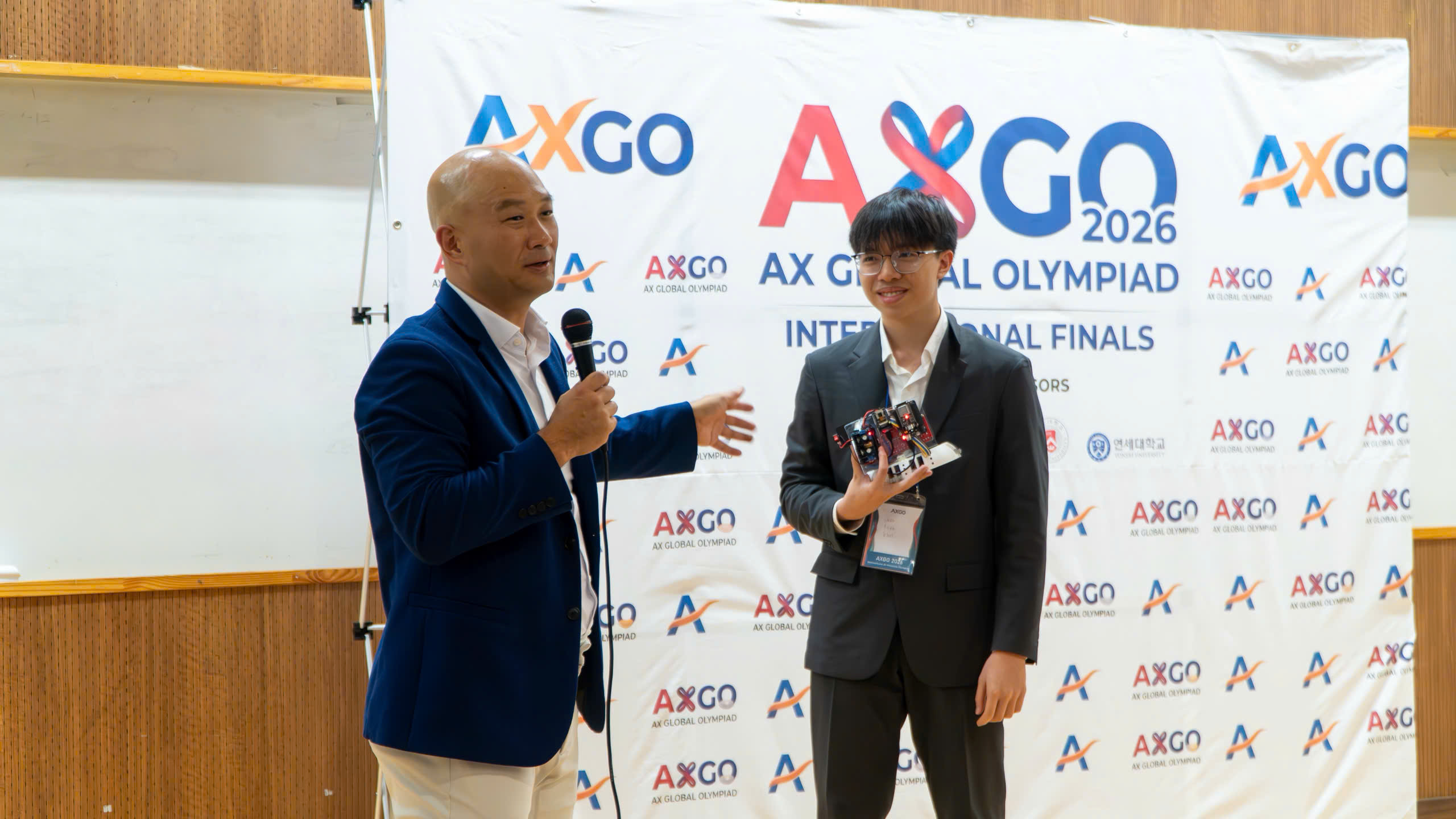 Khoi presenting V-Haptic Sight with an AX Global Olympiad host.